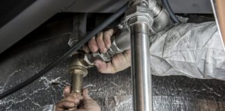 Hydraulik montuje stalowe rury instalacji wodno-kanalizacyjnej