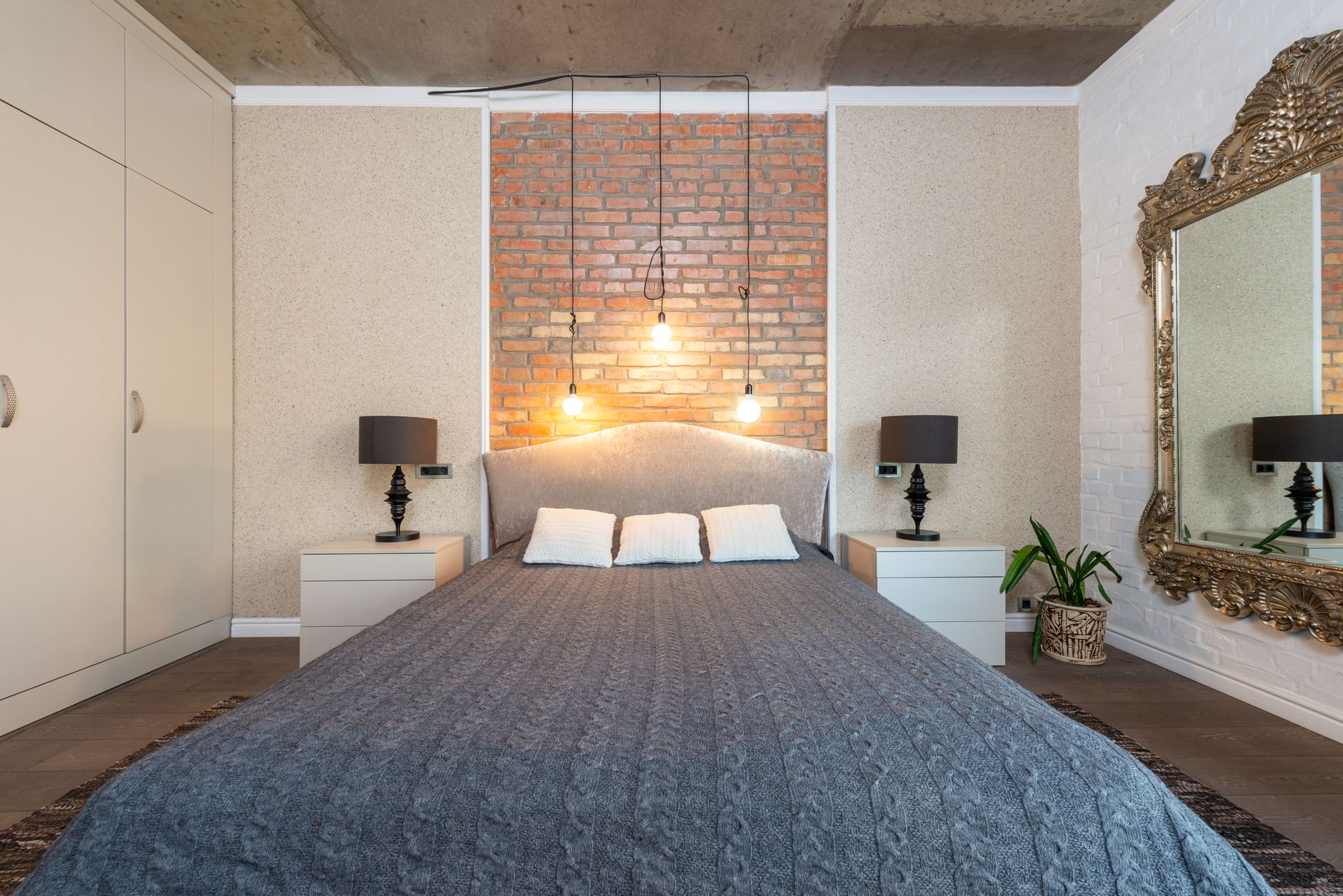 Nowoczesna sypialnia z ceglaną ścianą i eleganckimi dodatkami