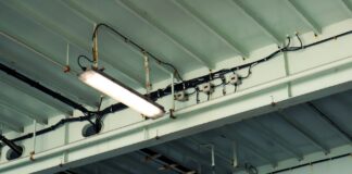 Przemysłowa lampa sufitowa i okablowanie w hali magazynowej e-commerce